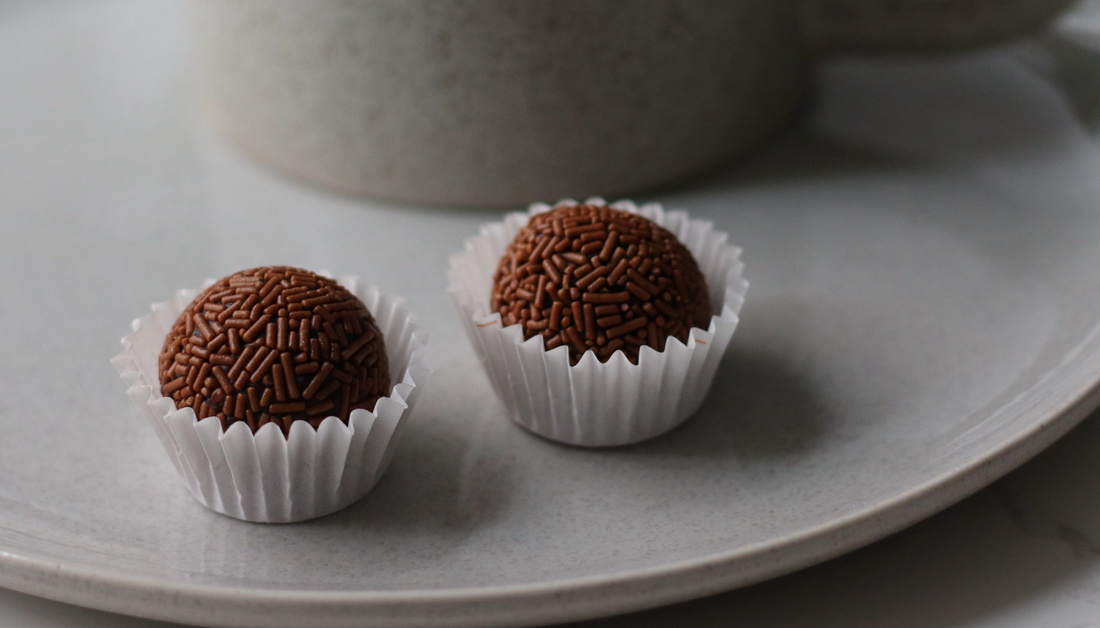 Soft Brazilian brigadeiros coated in chocolate sprinkles, served on a plate