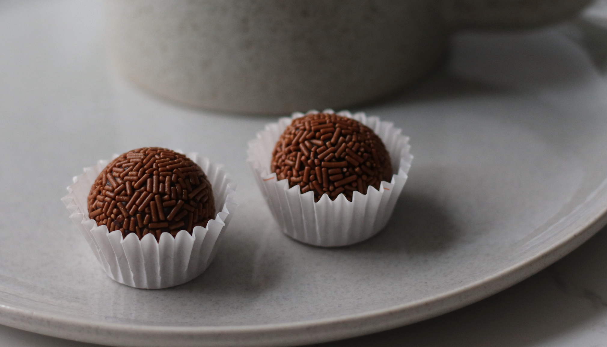 Soft Brazilian brigadeiros coated in chocolate sprinkles, served on a plate